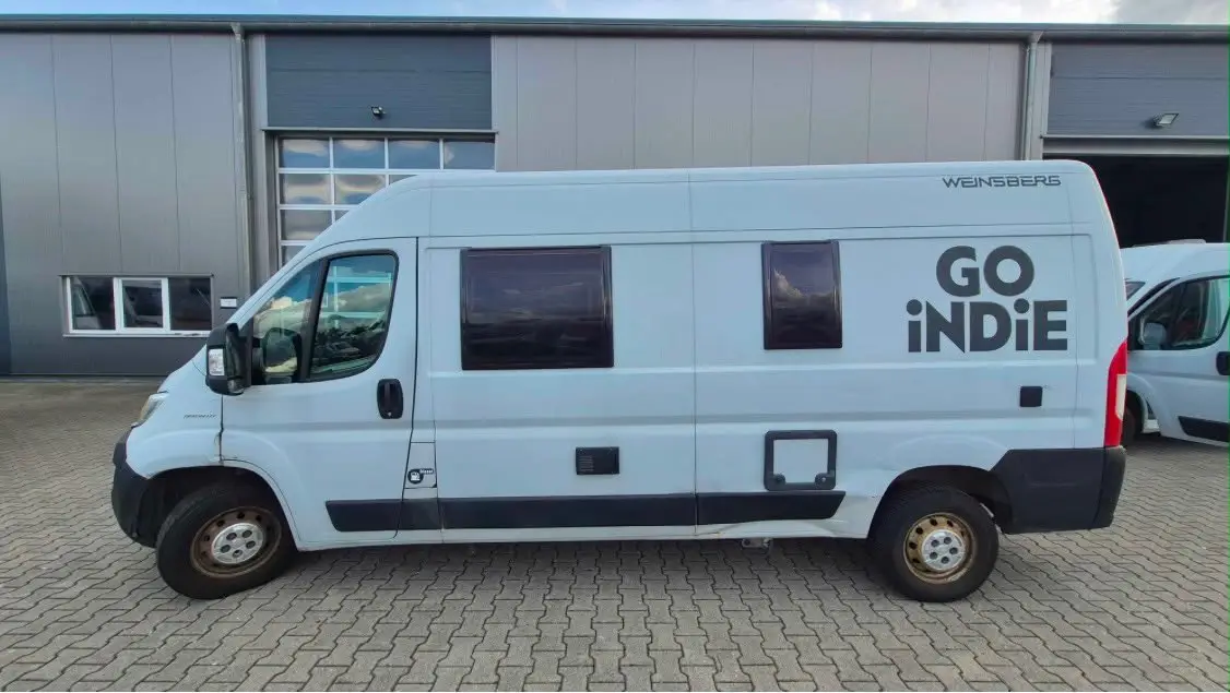 Fiat Ducato Weinsberg CaraBus campervan in side profile outside a workshop