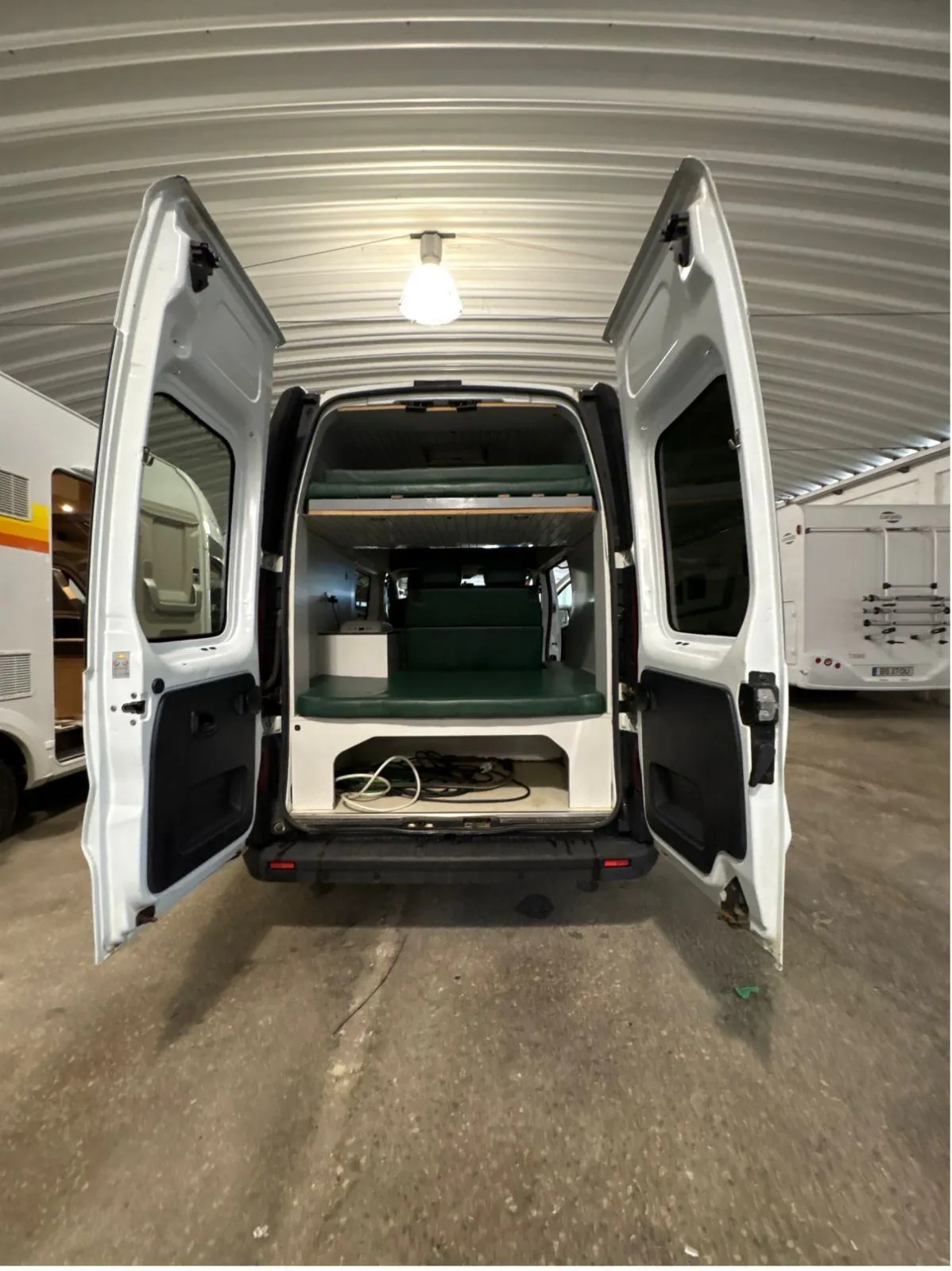 Rear doors open on the Fiat Talento campervan in a workshop