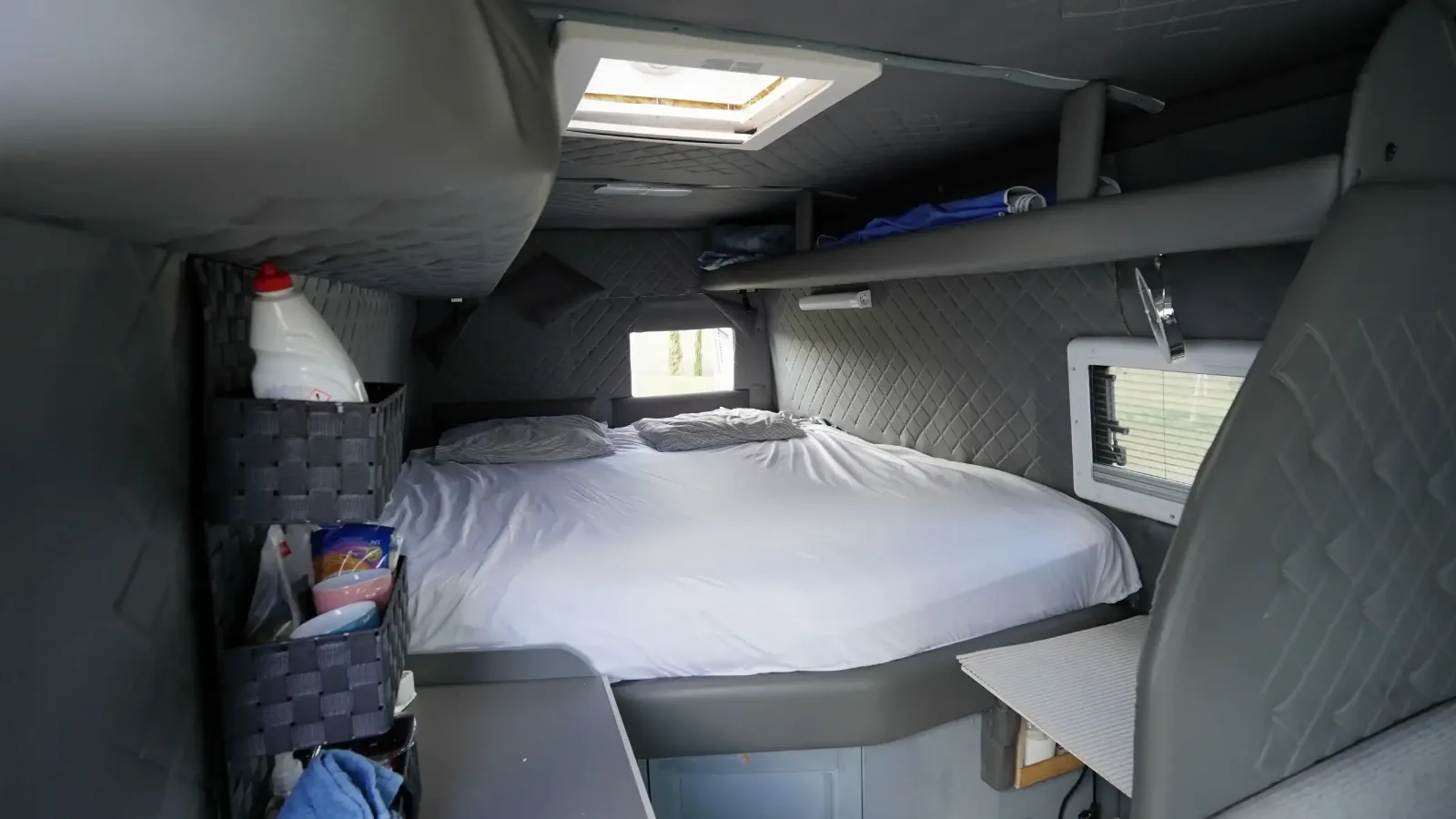 Bed and table in the Mercedes-Benz Sprinter campervan below the roof light