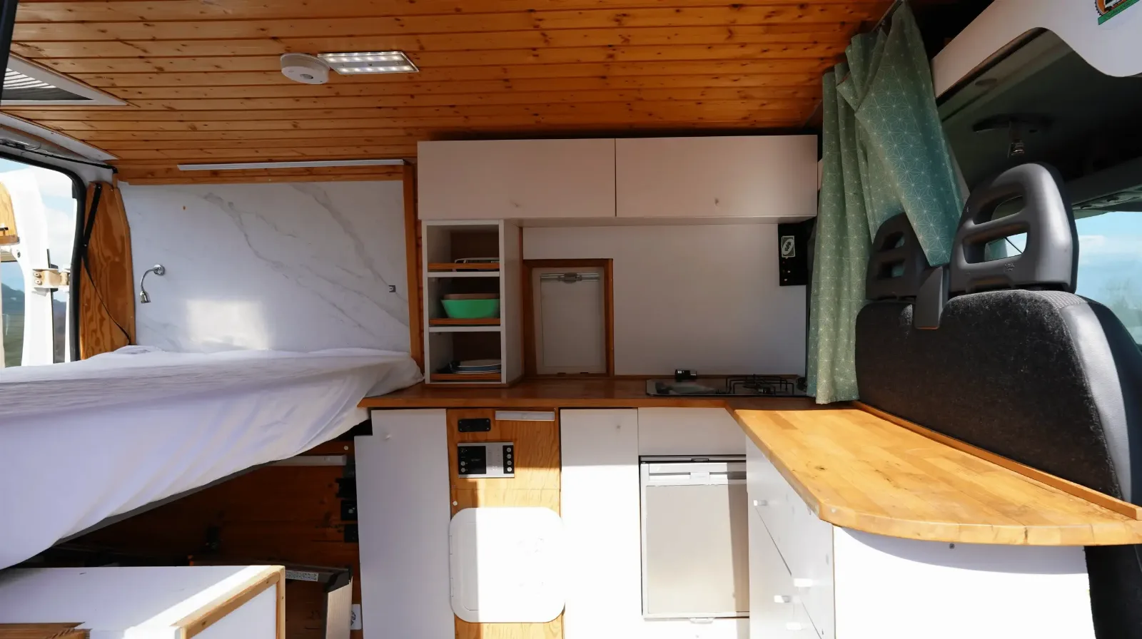 Inside the Peugeot Boxer campervan, with the bed, fridge and kitchen units