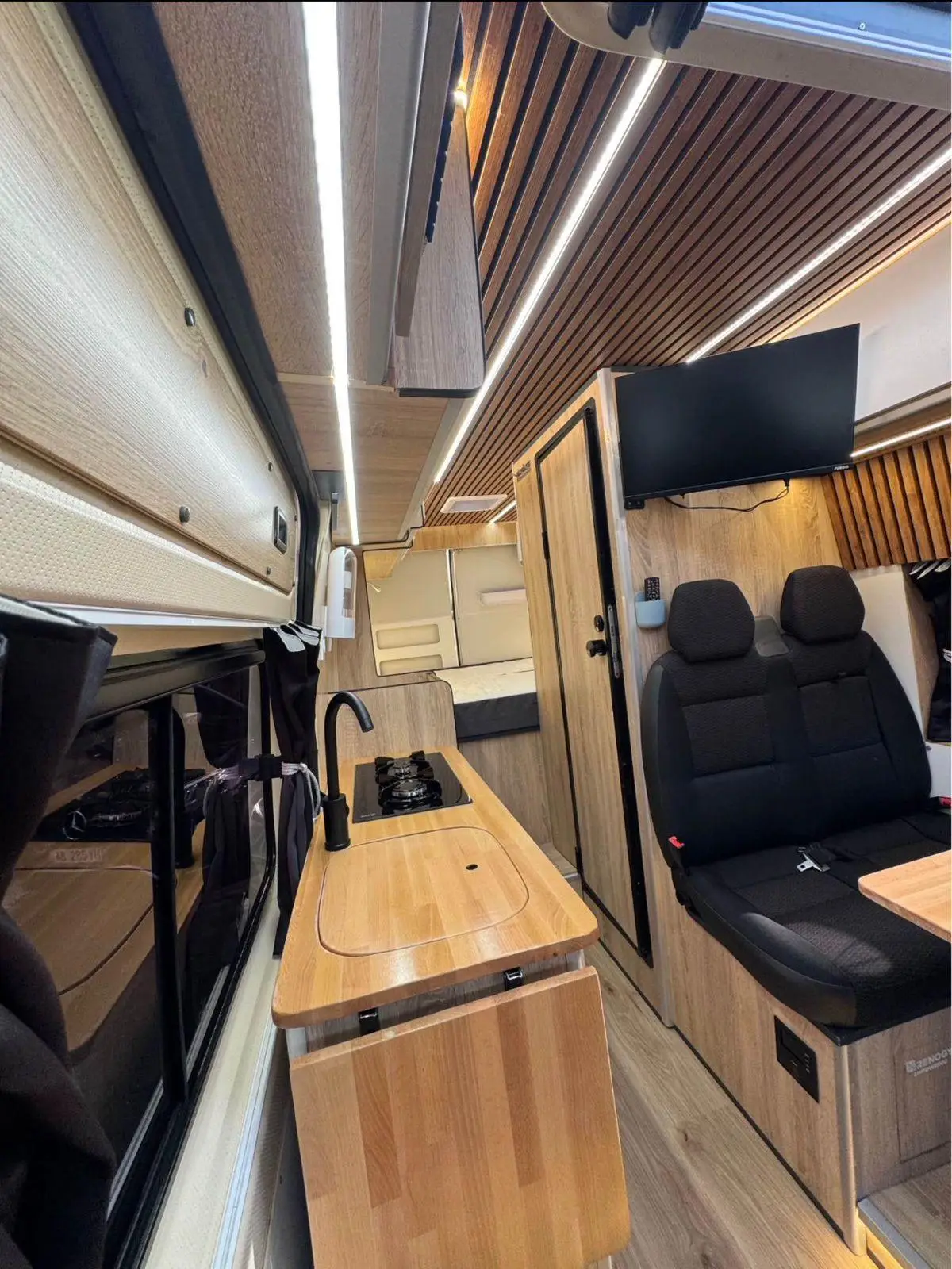 Inside the Peugeot Boxer campervan, looking forward past the galley to the cab seats
