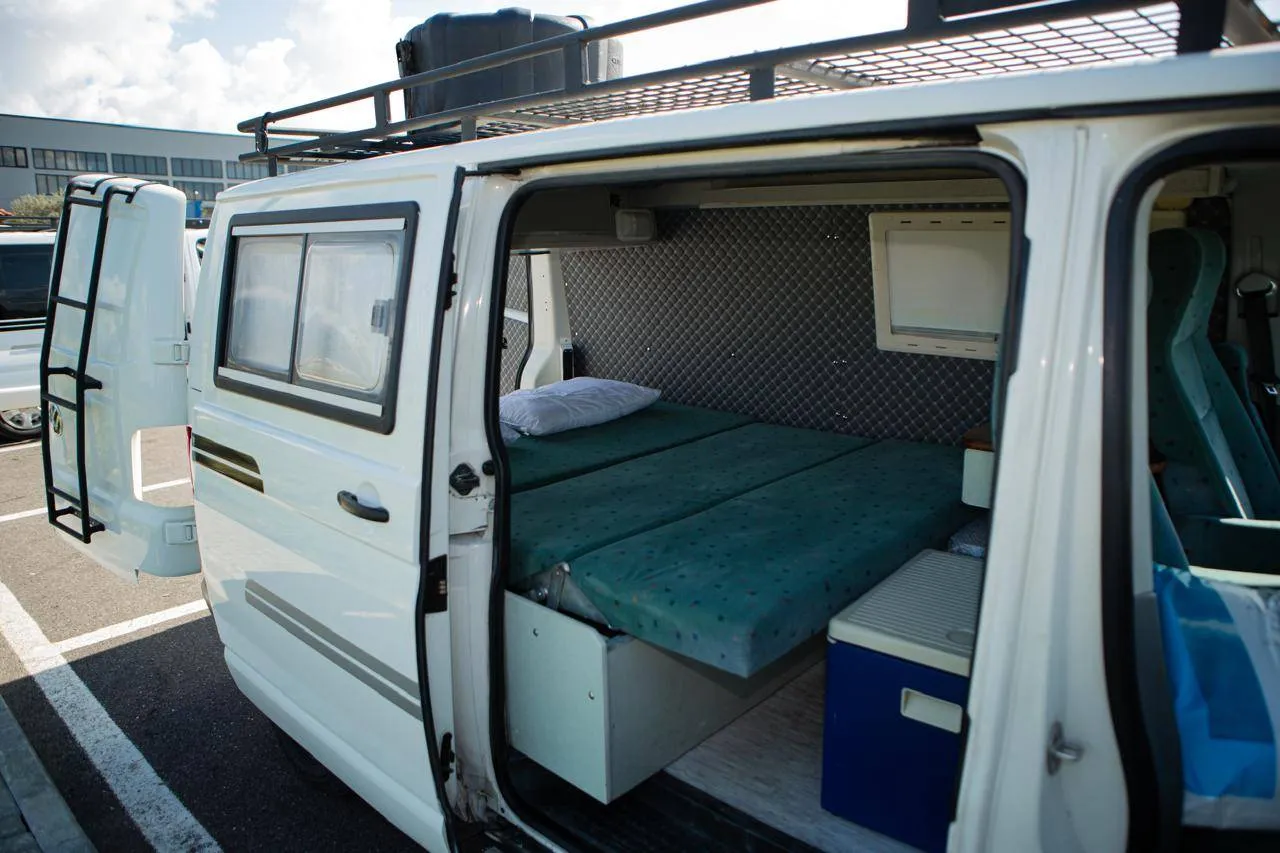 Side door open on the Volkswagen Transporter T5 campervan, showing the bed and cool box