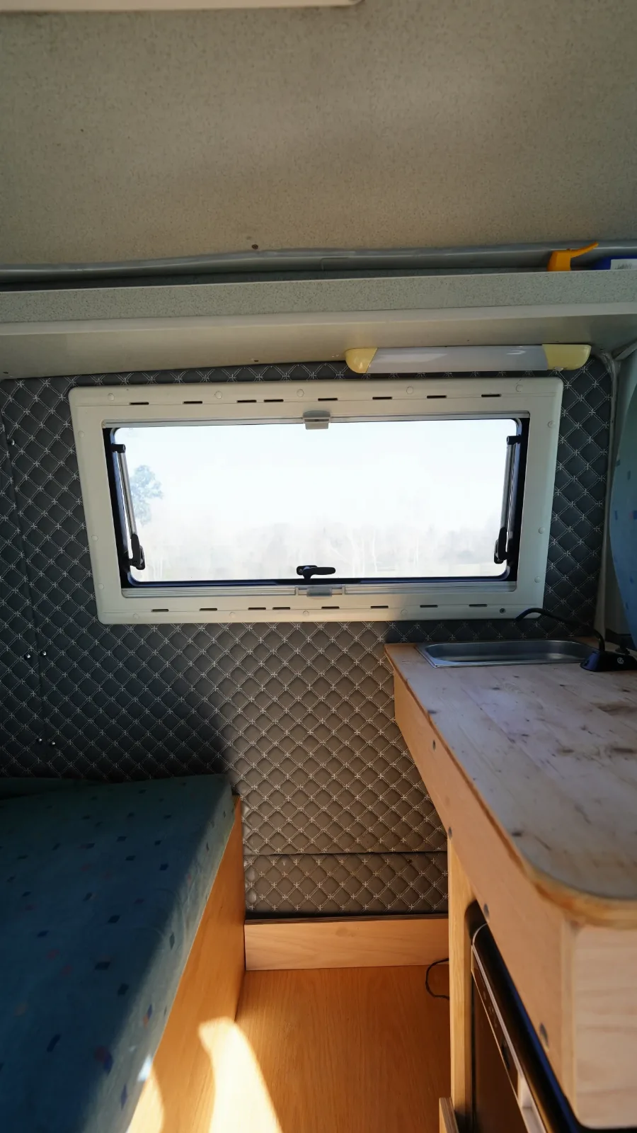 Window, worktop and bed inside the Volkswagen Transporter T5 campervan