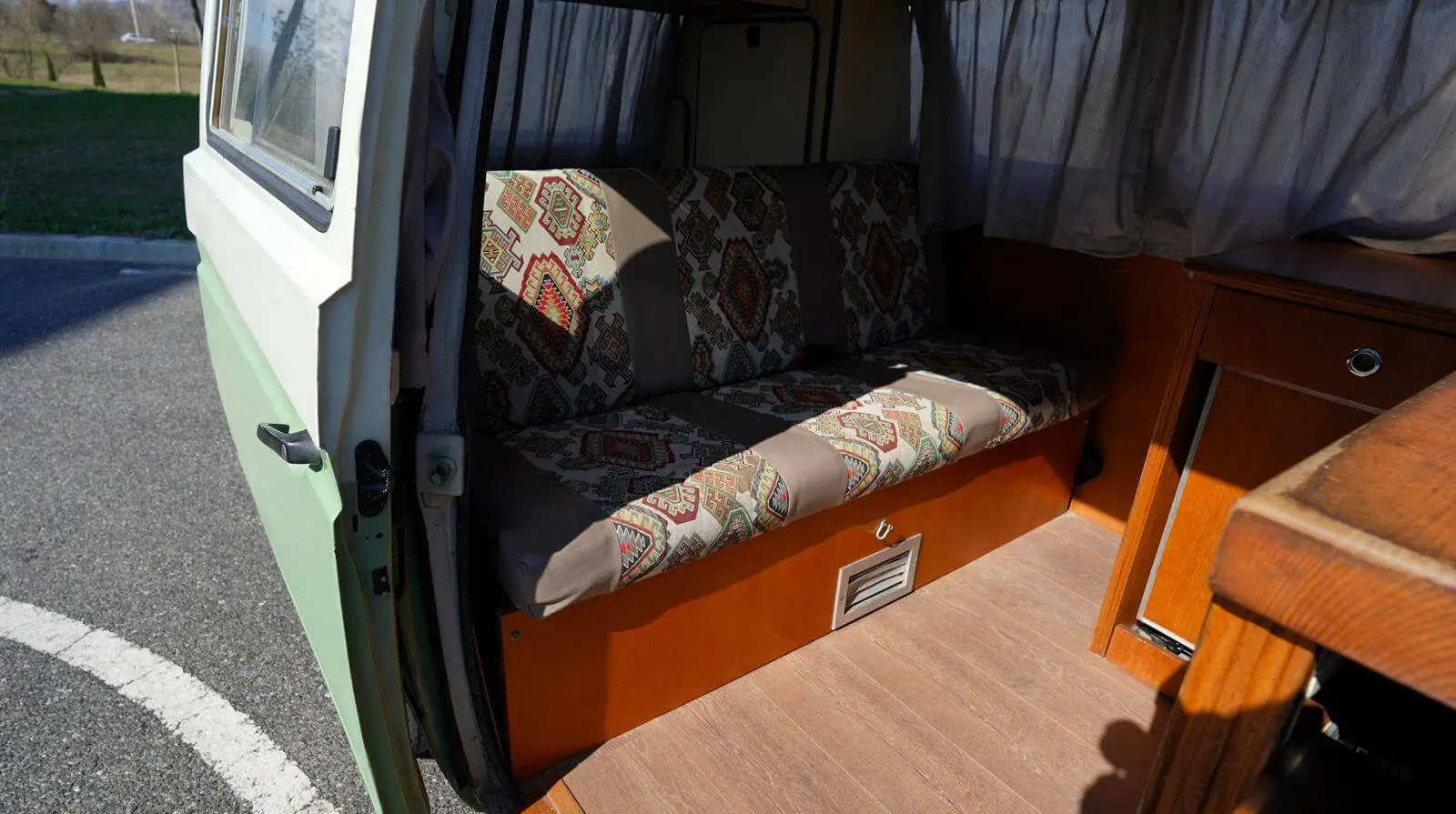 Patterned bench seat and wooden cabinets in the Volkswagen Westfalia campervan